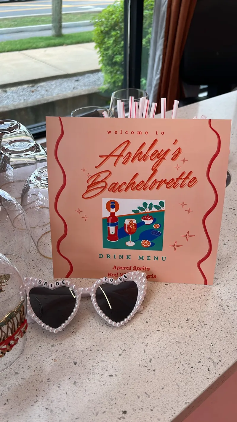 A welcome sign and drink menu for a bachelorette party, with heart sunglasses
